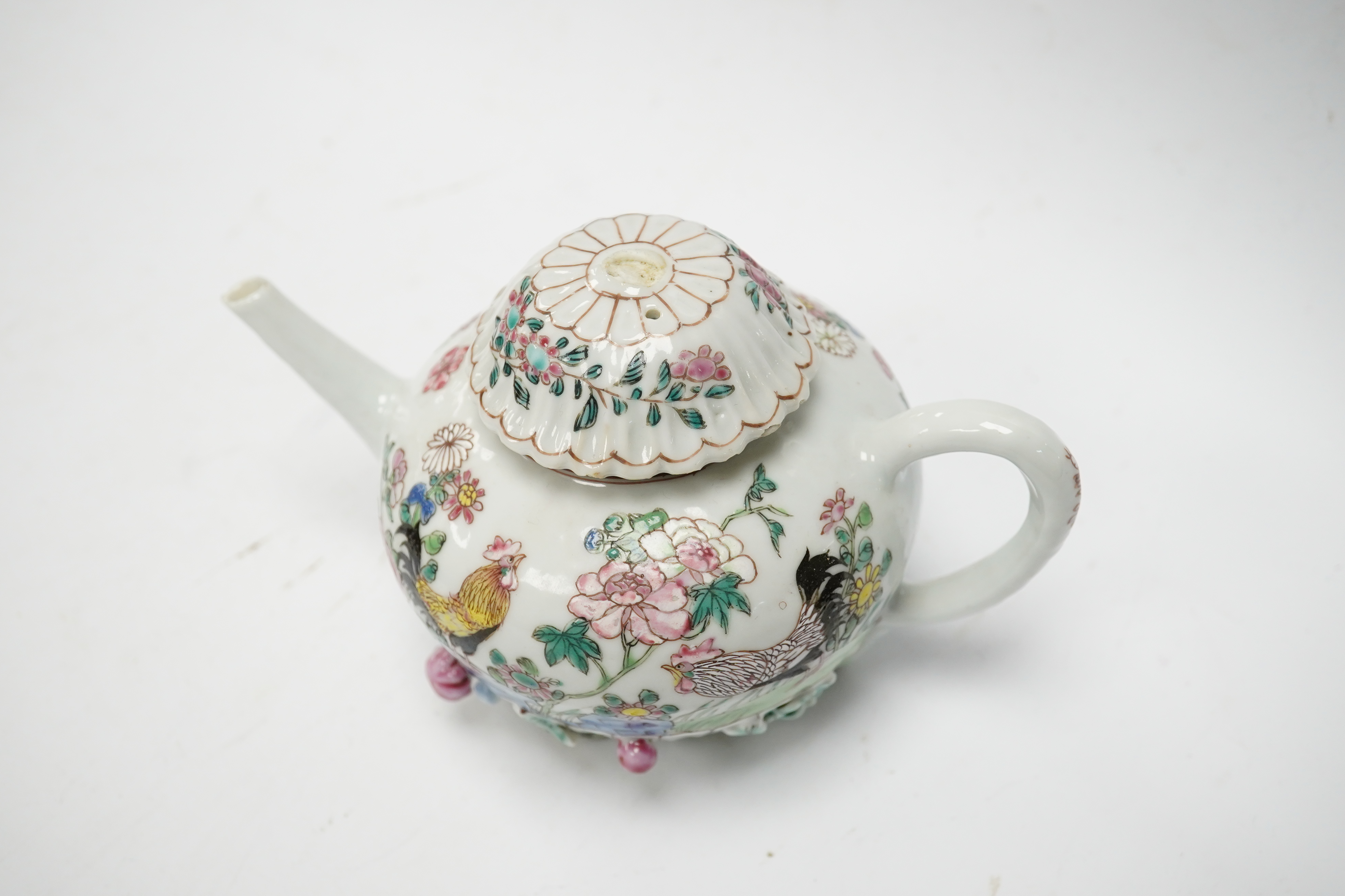 A Chinese famille rose chrysanthemum moulded teapot, early Qianlong period, painted with a cockerel amongst flowers, on a cage work base, 10cm high. Condition - restored